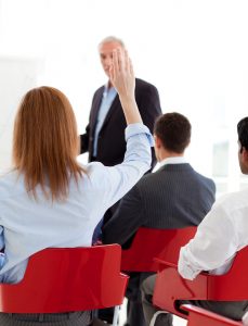 Businesswoman raising her hand up at a conference. Business concept. - Event Technology for Corporations - The Key to Efficient Planning