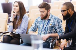 Multiethnic group of young business people using laptop sitting on meeting in conference hall - Looking for Sponsors? How to Find Backers for Your Event