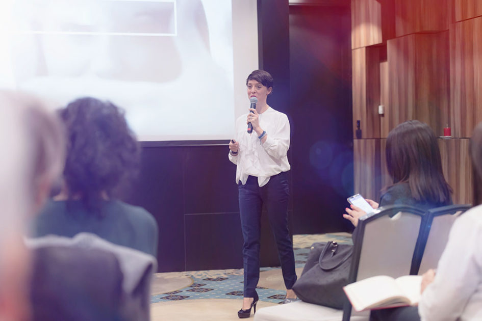 beautiful business woman with microphone in her hand speaking at the conference or seminar - Top 5 Event Suppliers for Staffing in the UK and Spain
